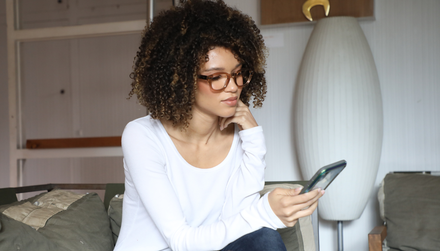 girl on couch accessing lights with smart technology