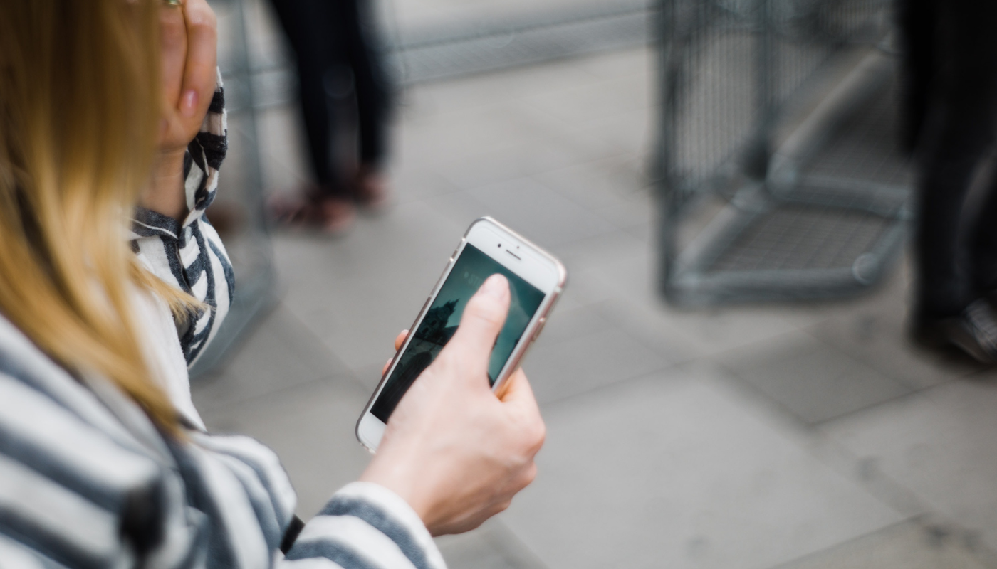 woman using phone depicting how property managers can improve the guest experience